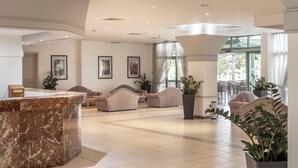 A spacious lobby with a marble reception desk, multiple seating areas, and large windows allowing natural light. - Antigoni Hotel (Paralimni)