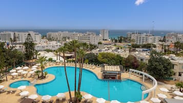 Una piscina al aire libre, sombrillas, tumbonas