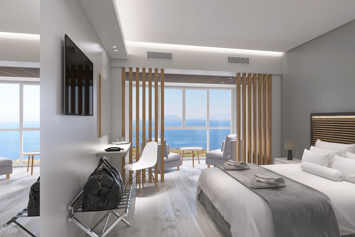 Une chambre d’hôtel moderne avec un grand lit, un bureau et une vue sur la mer.