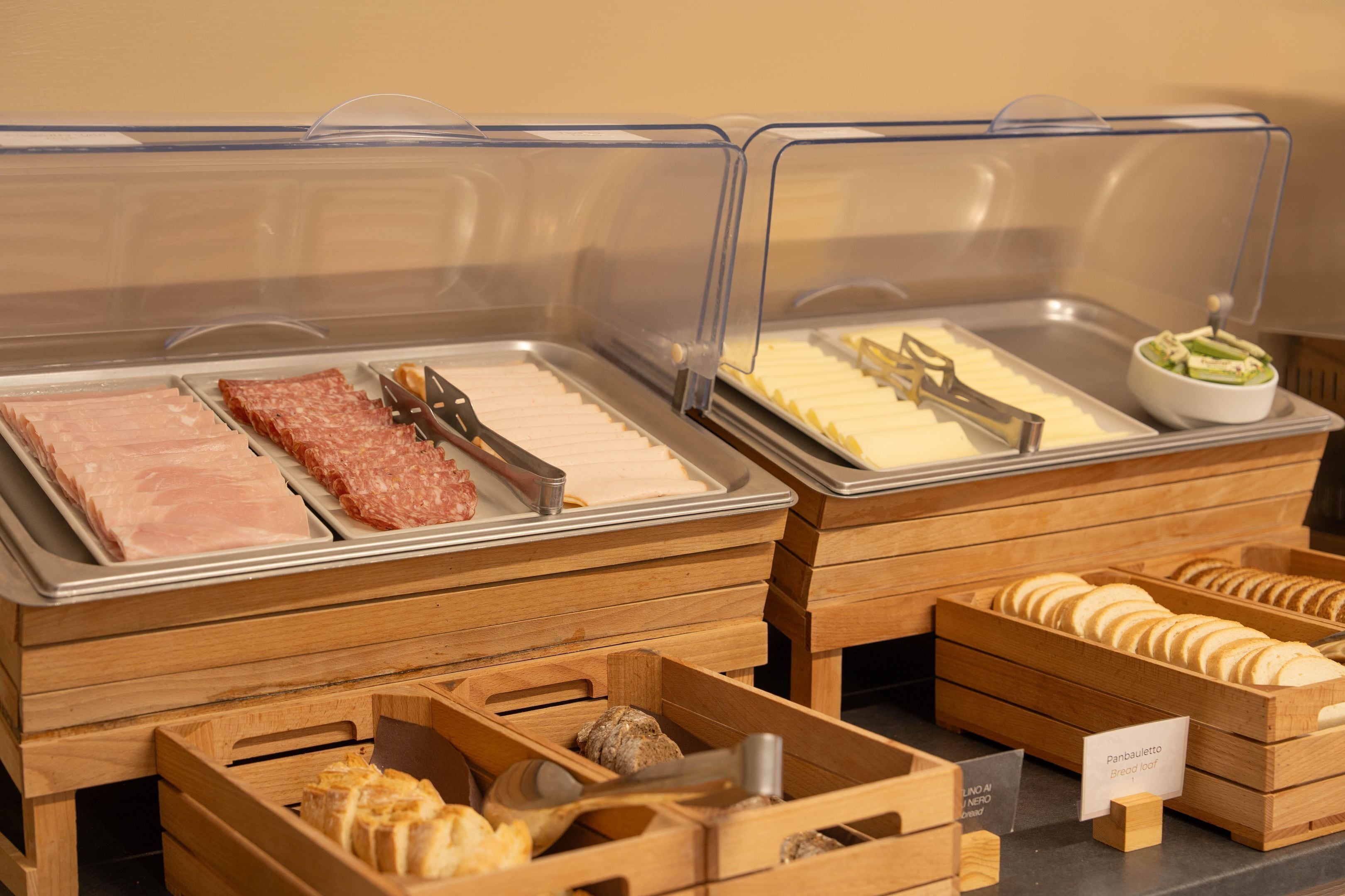 Een buffet met diverse gerechtjes, waaronder vleeswaren, kazen en brood.