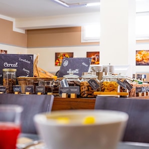 A breakfast buffet with various food options and labels. - Park Hotel Residence (Orbetello)