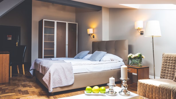Un dormitorio moderno con cama, mesita de noche, lámpara y armario.