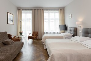 Superior driepersoonskamer | Luxe beddengoed, een minibar, een kluis op de kamer, een bureau
