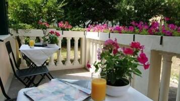 A table with a potted plant, a glass of orange juice, and a menu.