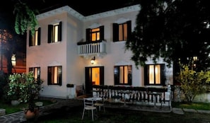 A two-story building with a balcony, outdoor seating, and a well-lit entrance. - Villa Crispi (Mestre)