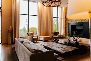 Una sala moderna con un sofá, sillones, una mesa de centro y una chimenea.