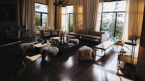 Un salón amplio con un ventanal grande, un sofá, una mesa de centro y una chimenea.