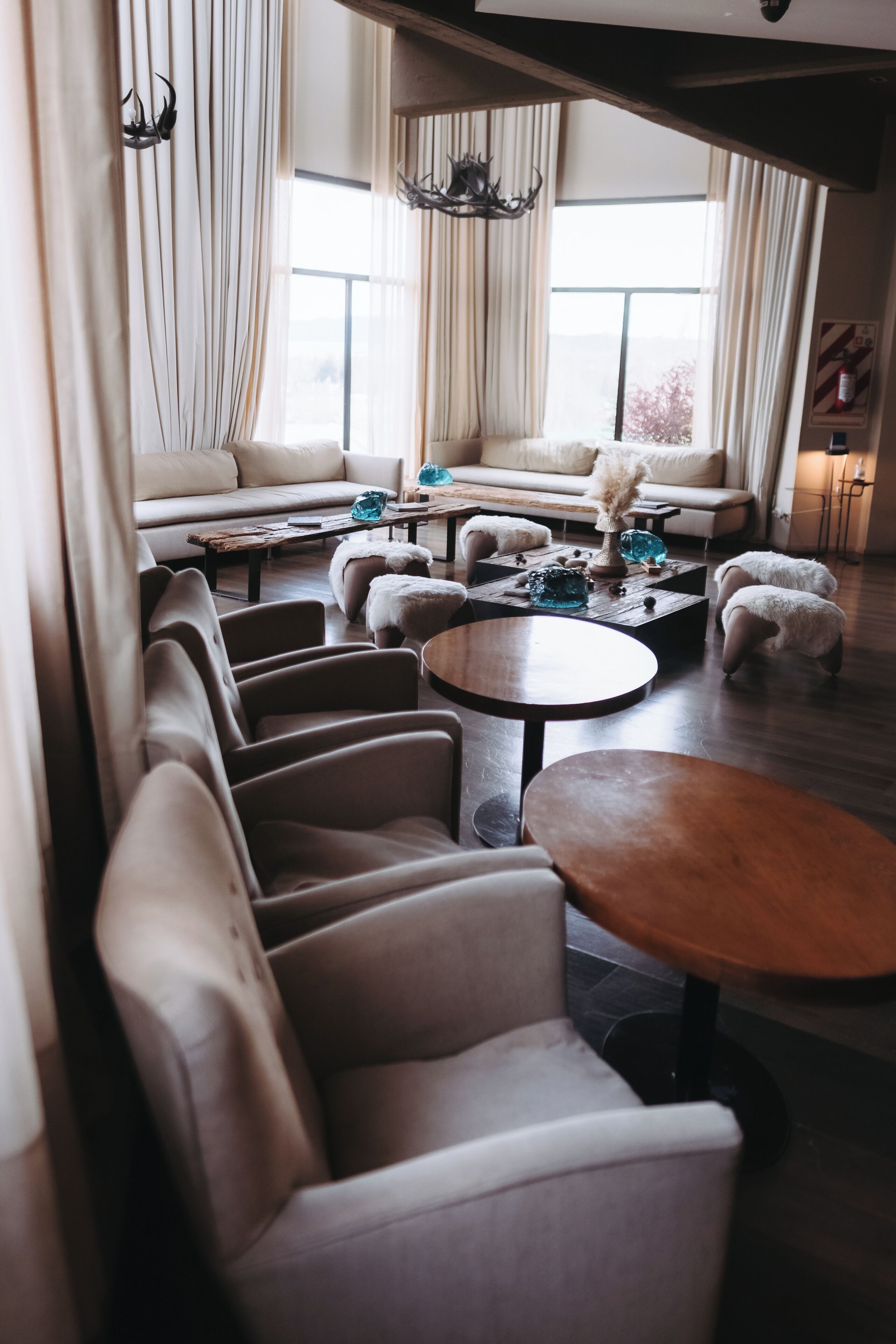 Un salon moderne comprenant un ensemble de canapés, plusieurs fauteuils, une table basse et des objets décoratifs.