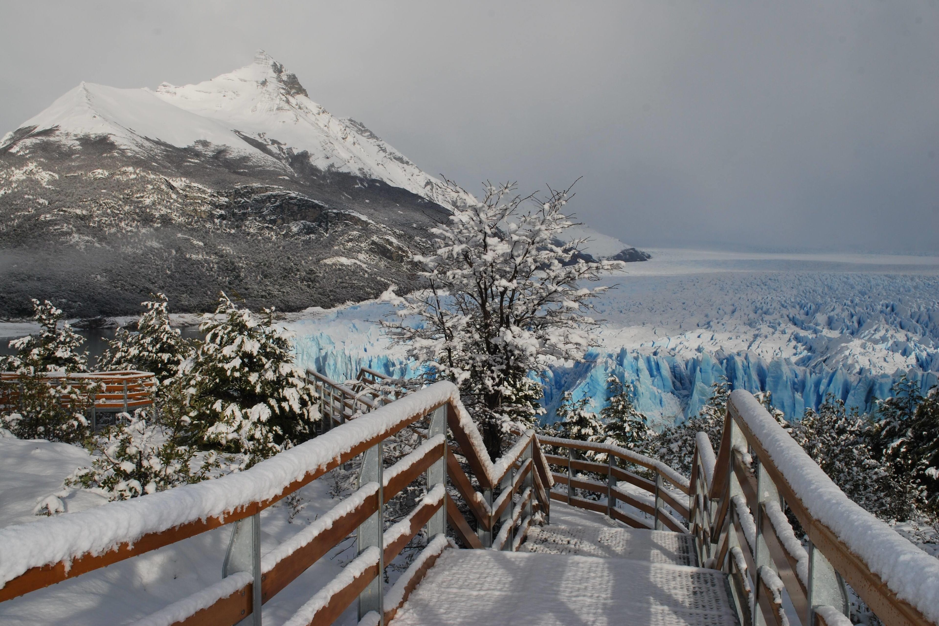 Paisaje nevado de montaña con un glaciar al fondo.