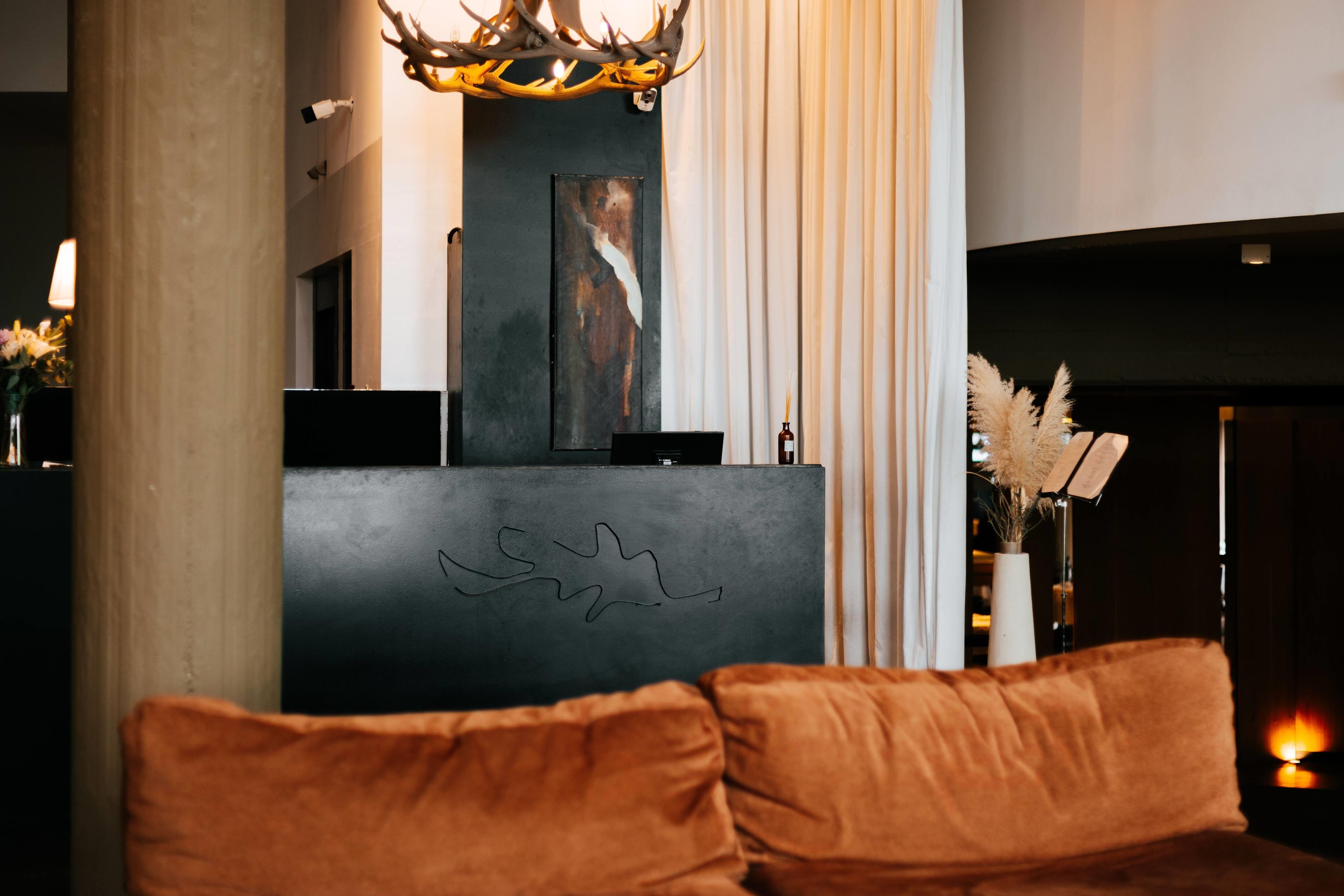 Ein modernes Interieur mit einer Rezeption, einem Kamin und einer Couch.