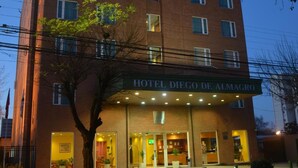 Ein mehrstöckiges Hotel mit einer markanten Eingangspartei und einem Schild mit der Aufschrift "HOTEL DIEGO DE ALMAGRO".