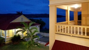 A two-story building with a balcony overlooking a body of water.