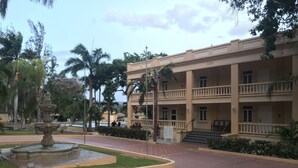 A multi-story building with a central courtyard, a fountain, and a pool.