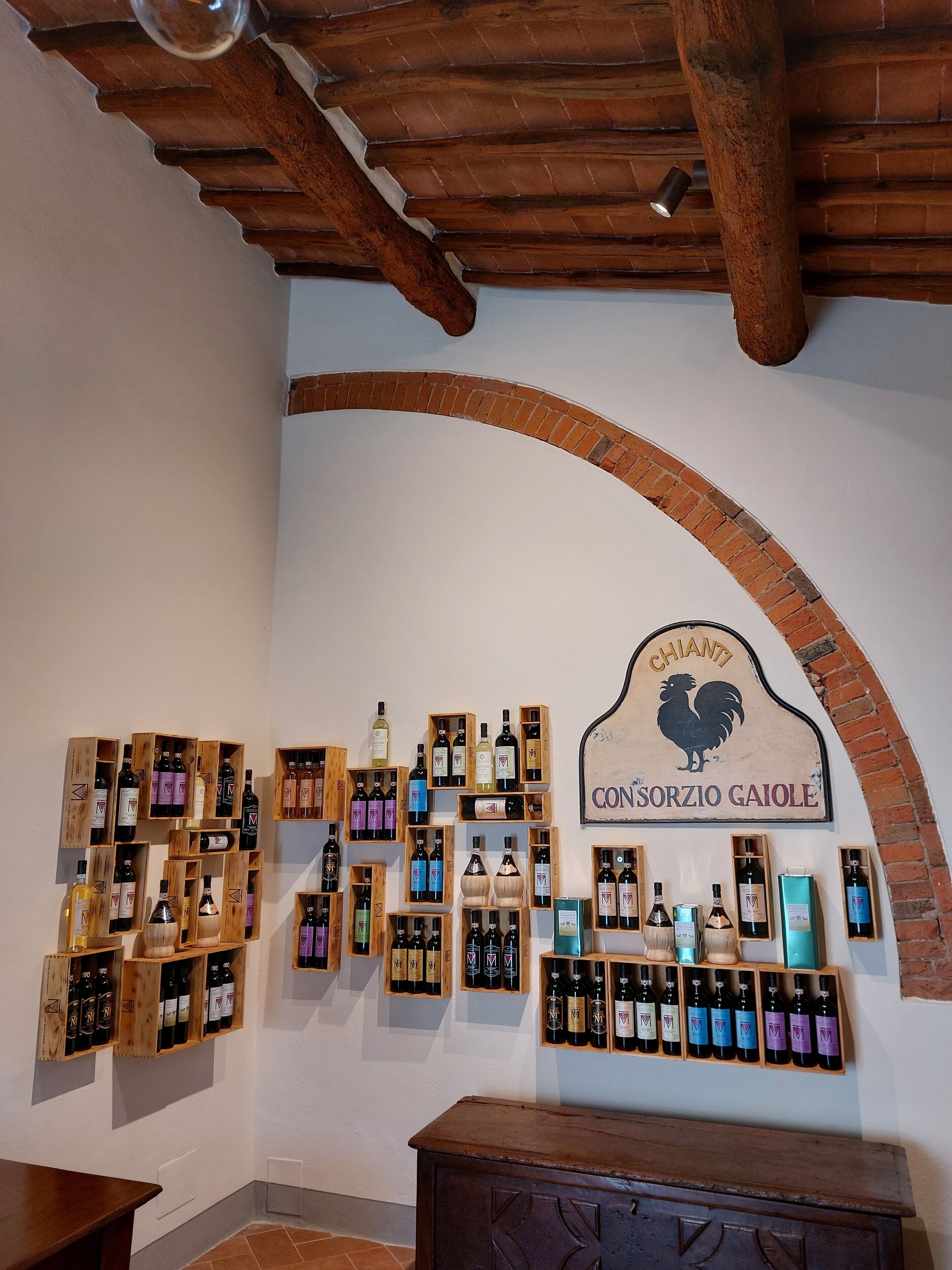 A wine cellar with wooden shelves displaying various bottles of wine.