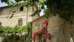 A stone building with a window and a light fixture. - Agriturismo San Sano (Gaiole in Chianti)