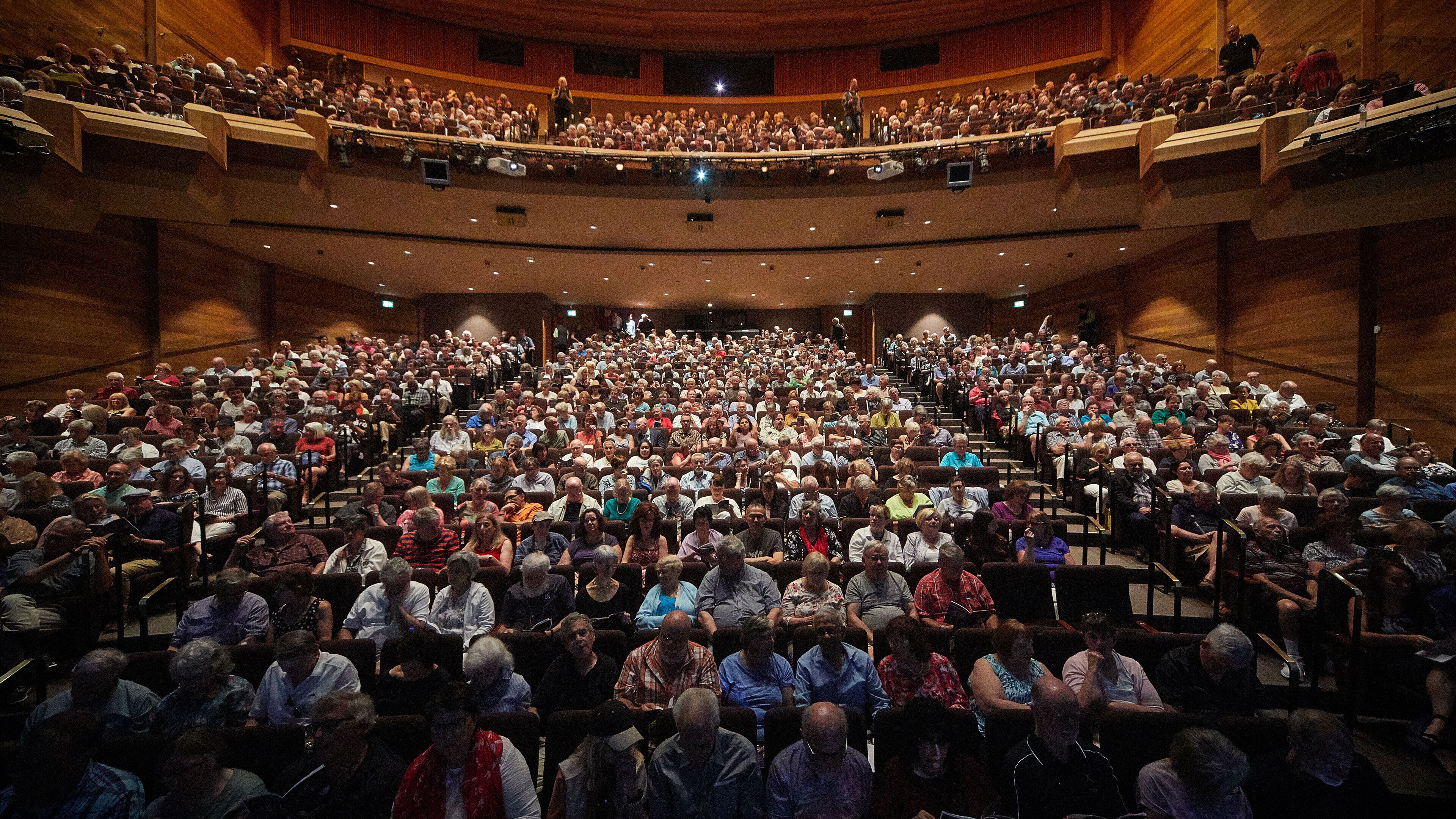 A large auditorium with tiered seating and a stage at the front.