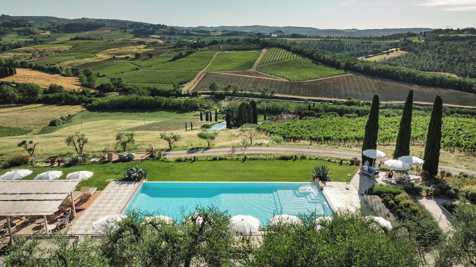 A pool area with a view of vineyards and rolling hills.