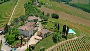 A large estate with multiple buildings, a swimming pool, and extensive vineyard fields. - Poderi Arcangelo (San Gimignano)