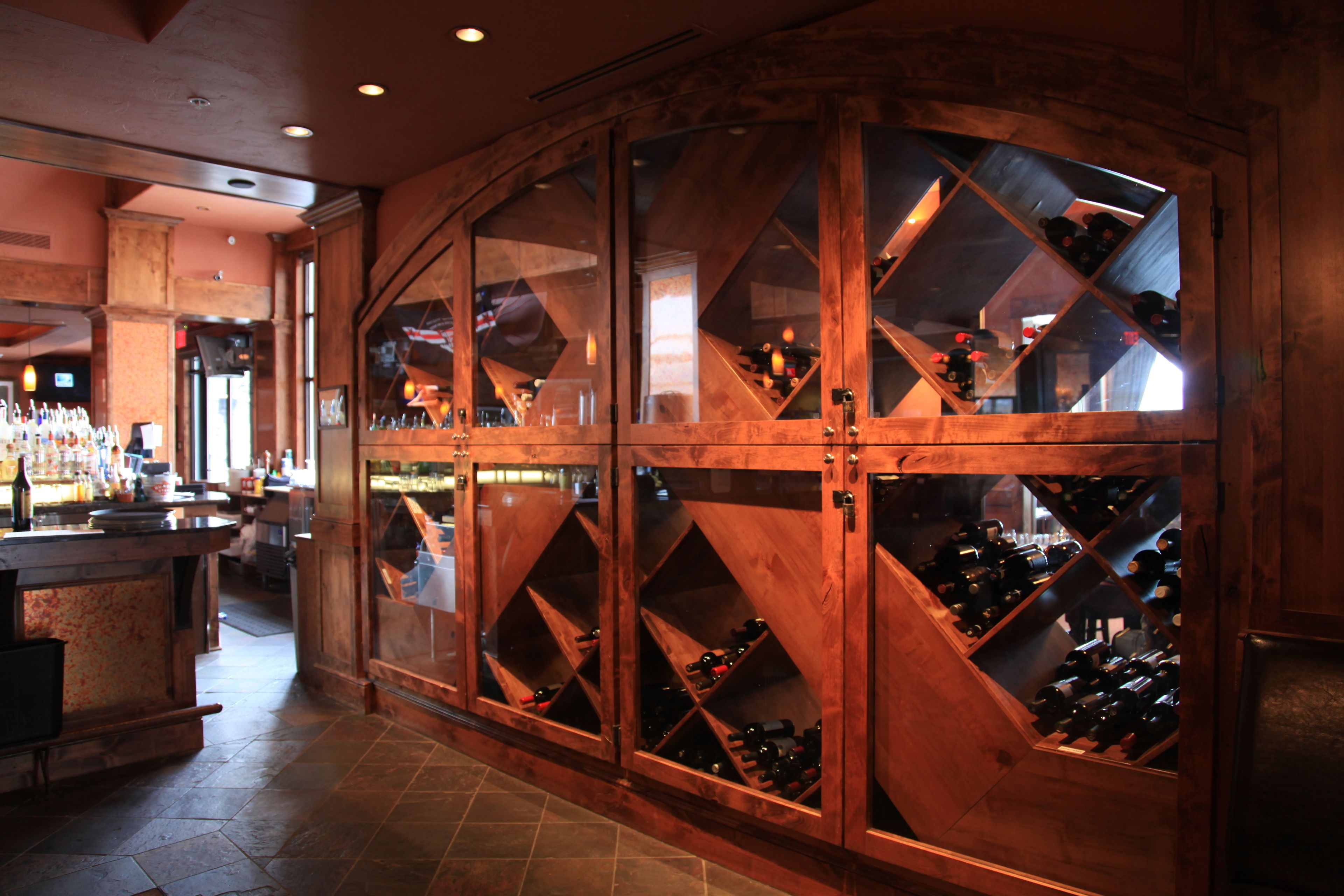 A wine cellar with wooden racks and a bar area with bottles.