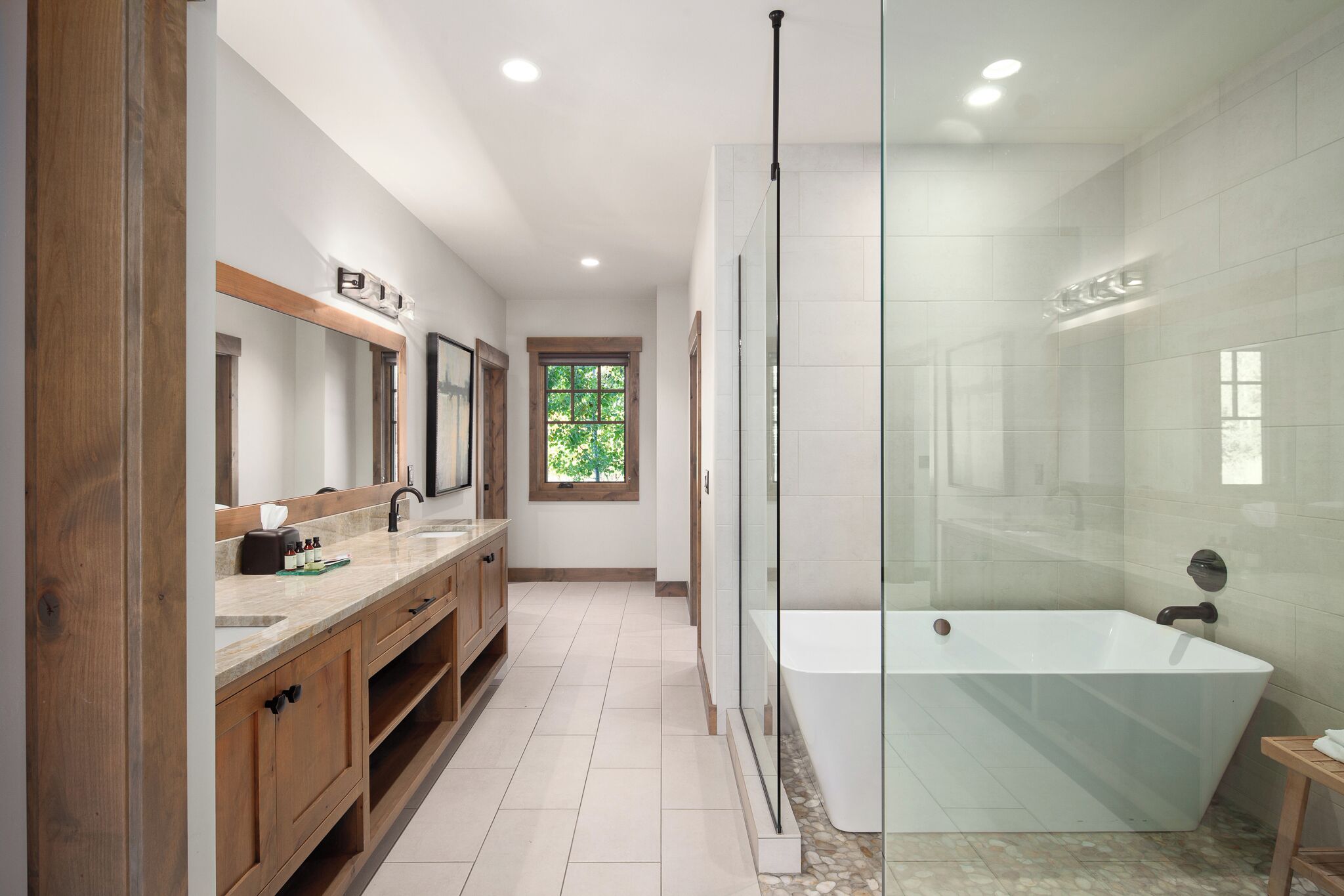 Un baño moderno con una bañera grande, cabina de ducha y tocador con espejo.