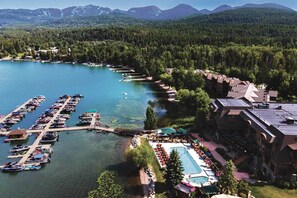 A lakeside resort with a marina, swimming pool, and mountain views.