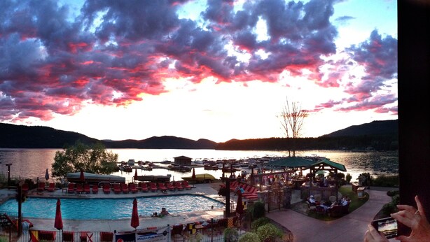 A lakeside resort with a swimming pool, lounge chairs, and a dock area. - Lodge at Whitefish Lake (Whitefish)