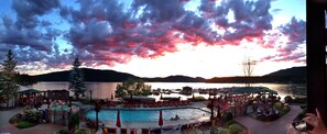 A lakeside resort with a swimming pool, lounge chairs, and a dock area. - Lodge at Whitefish Lake (Whitefish)