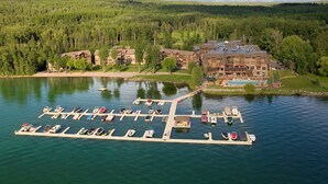 A lakeside resort with a docked boat area, a pool, and a large building with multiple stories. - Lodge at Whitefish Lake (Whitefish)