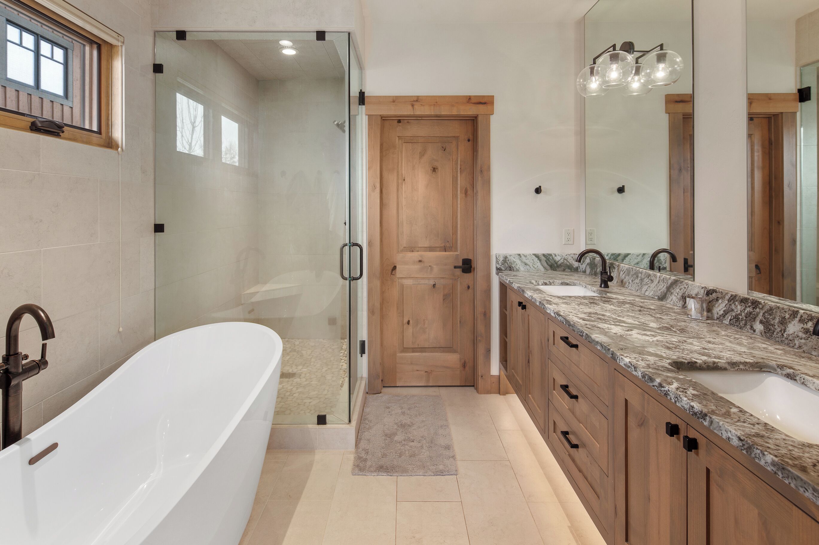 A modern bathroom with a freestanding bathtub, a walk-in shower, and a vanity with a large mirror.