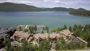 A lodge with multiple buildings, a marina, and a lake with mountains in the background. - Lodge at Whitefish Lake (Whitefish)