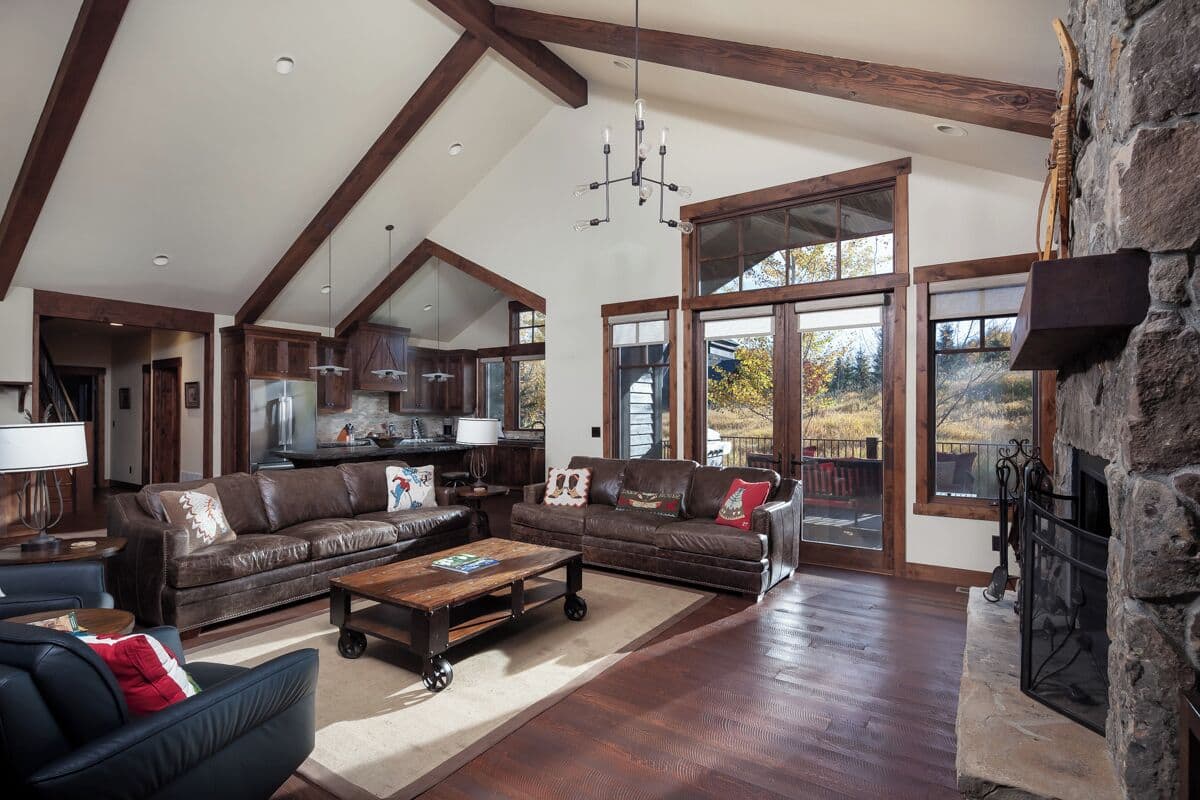 A spacious living room with a fireplace, leather sofas, and a stone accent wall.