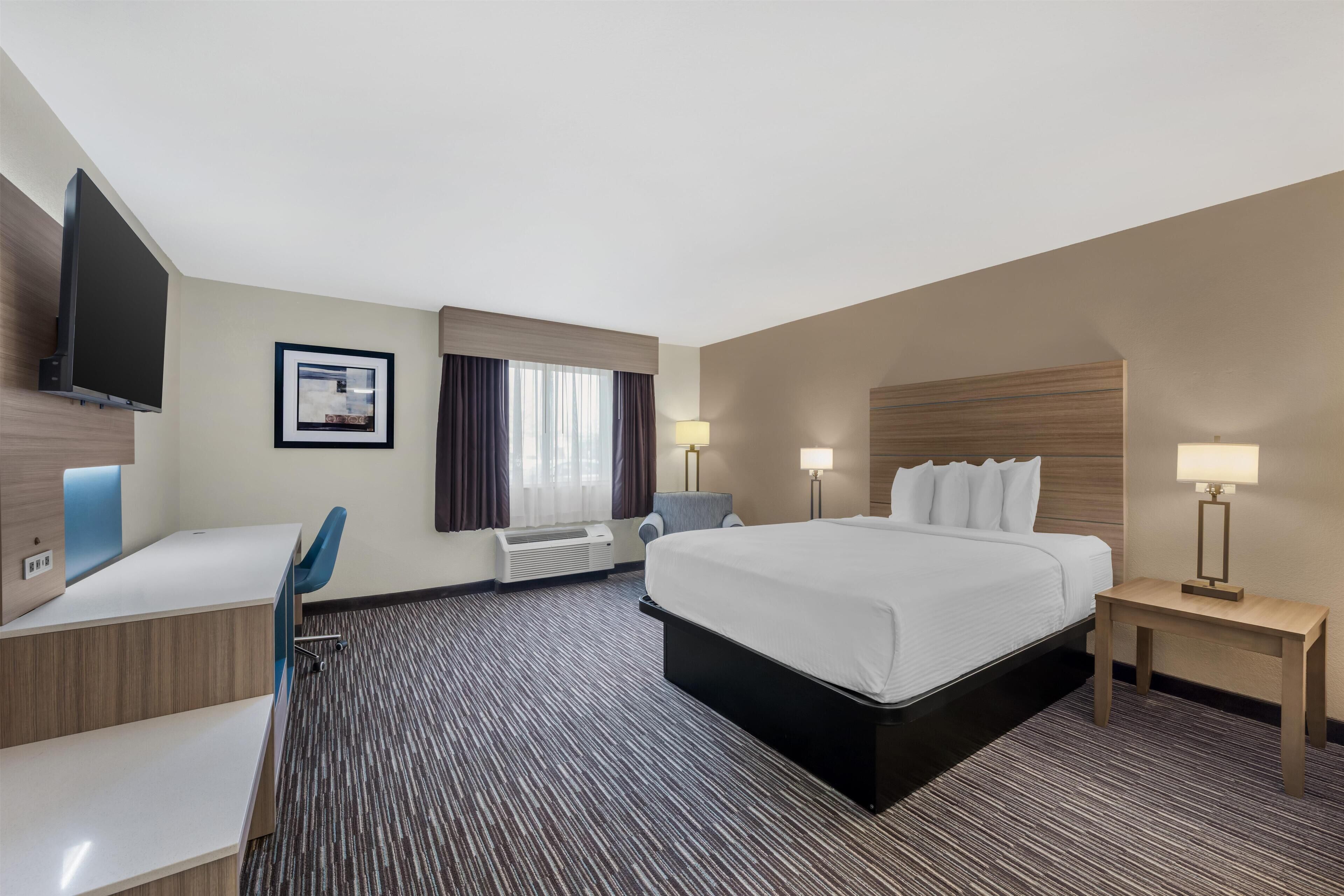 Yastık yüzeyli yatak, odada kasa, dizüstü bilgisayar çalışma alanı 