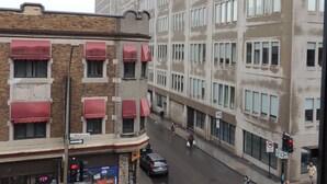 A street view with a building featuring a large WB logo, a corner with a brick facade, and a visible ATM. - Hotel Arena Palace Montreal (Montreal)