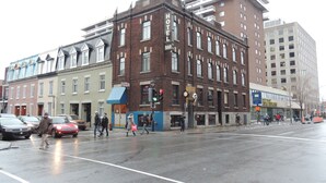 A multi-story hotel with a classic brick facade, a bar on the ground floor, and a visible entrance. - Hotel Arena Palace Montreal (Montreal)