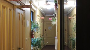 A narrow hallway with wooden doors, some labeled "TOILETTE". - Hotel Arena Palace Montreal (Montreal)