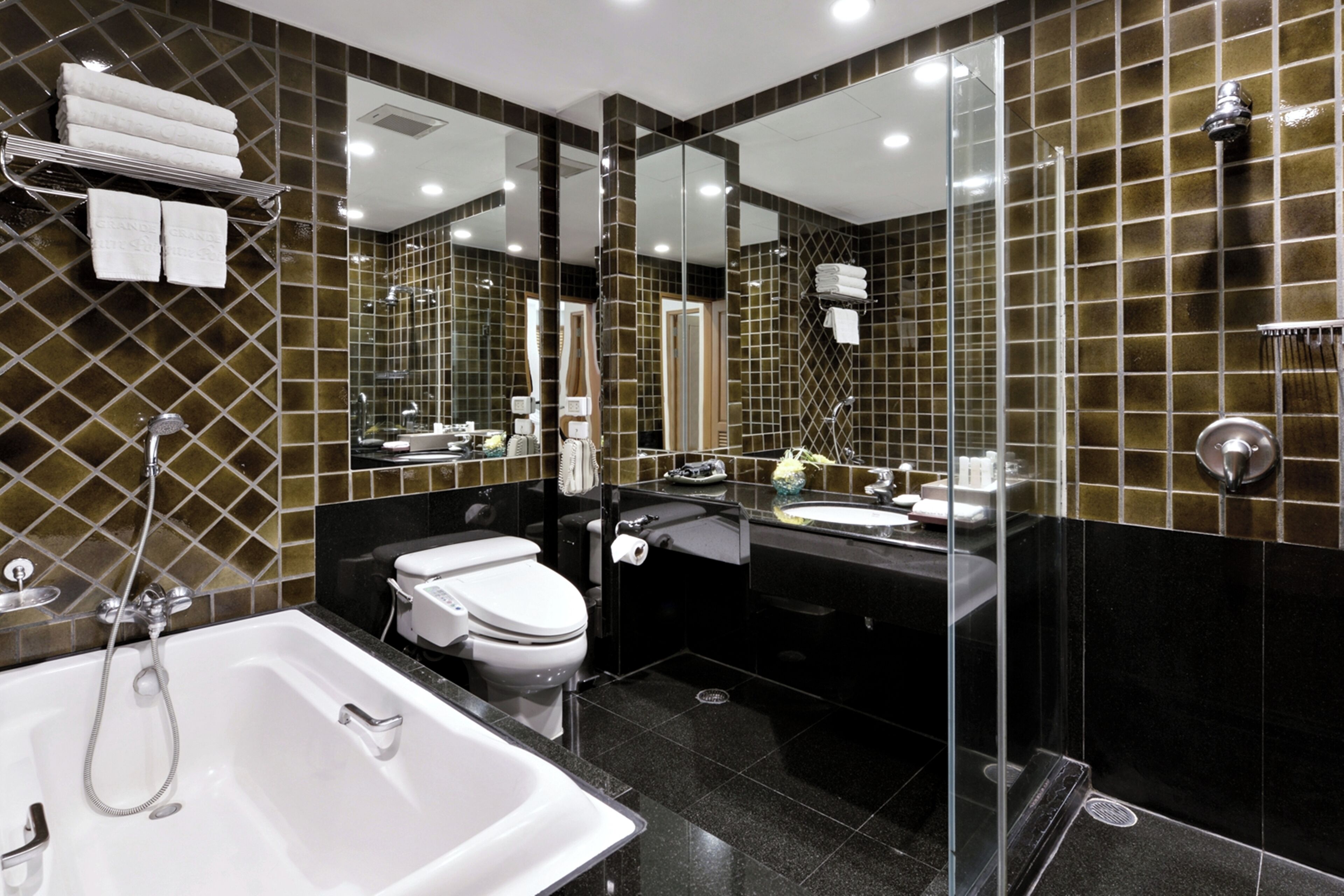 A modern bathroom with a bathtub, toilet, sink, and shower.