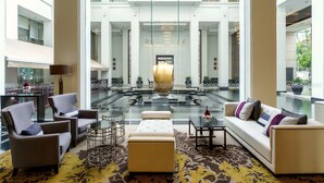 A spacious lobby with a central water feature, seating areas, and a view of the upper floors. - Grande Centre Point Ploenchit (Bangkok)