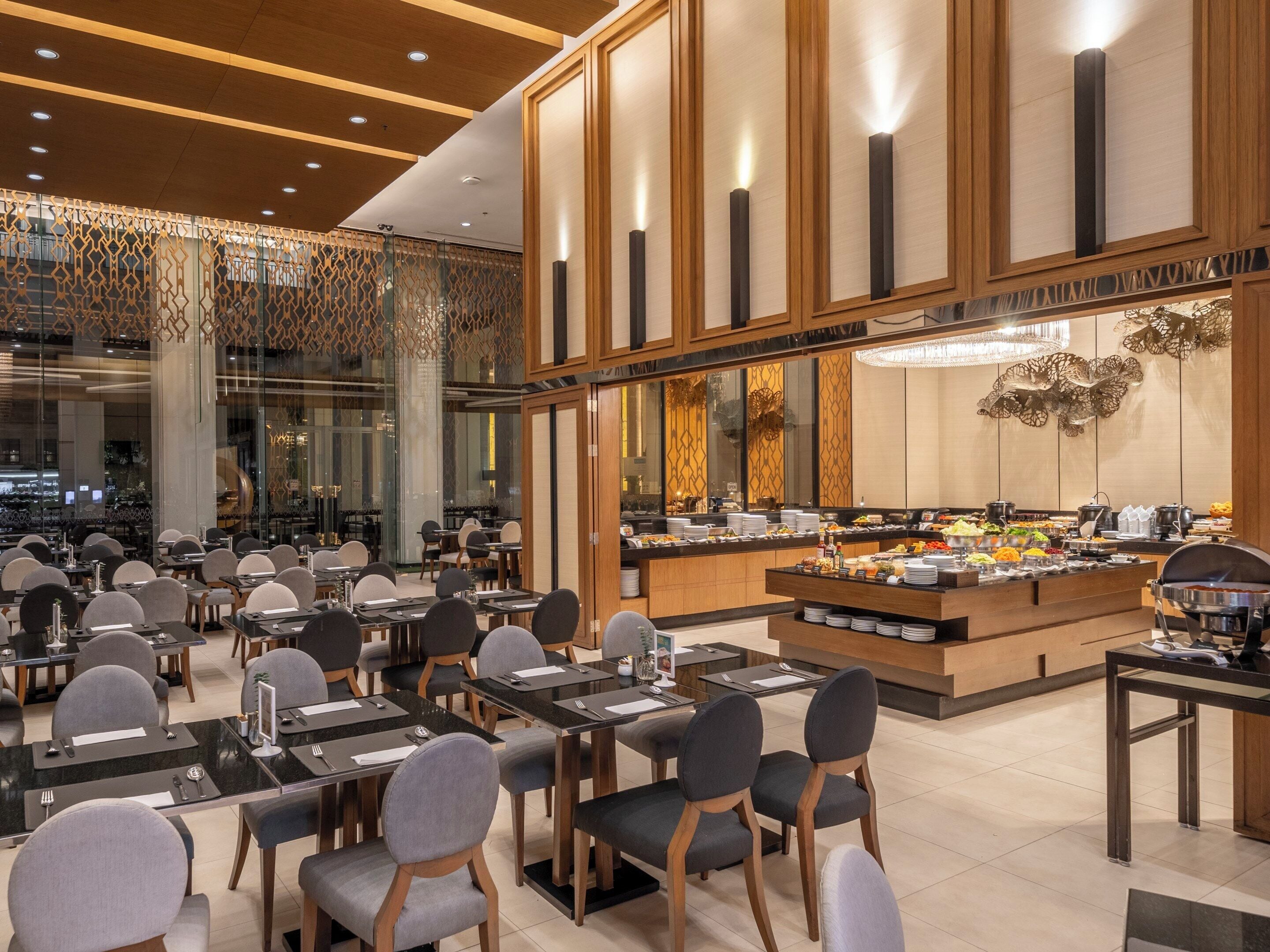 Un restaurant moderne doté d’un buffet, de tables et de chaises disposées pour accueillir les clients.