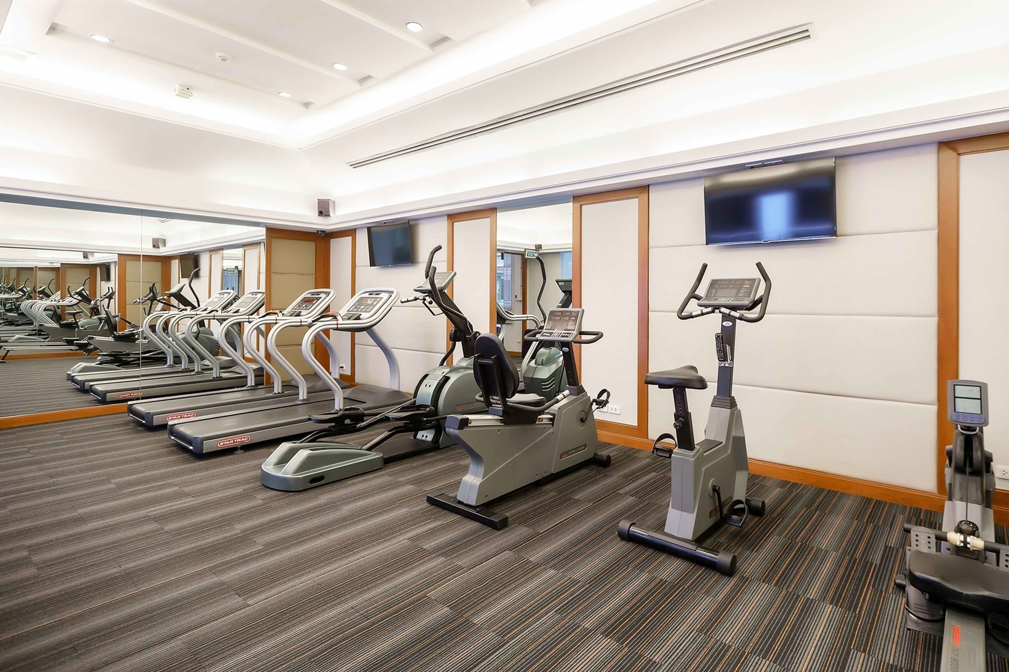 A gym with treadmills, elliptical machines, and stationary bikes.