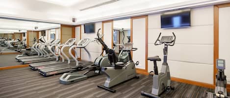 A gym with treadmills, elliptical machines, and stationary bikes.
