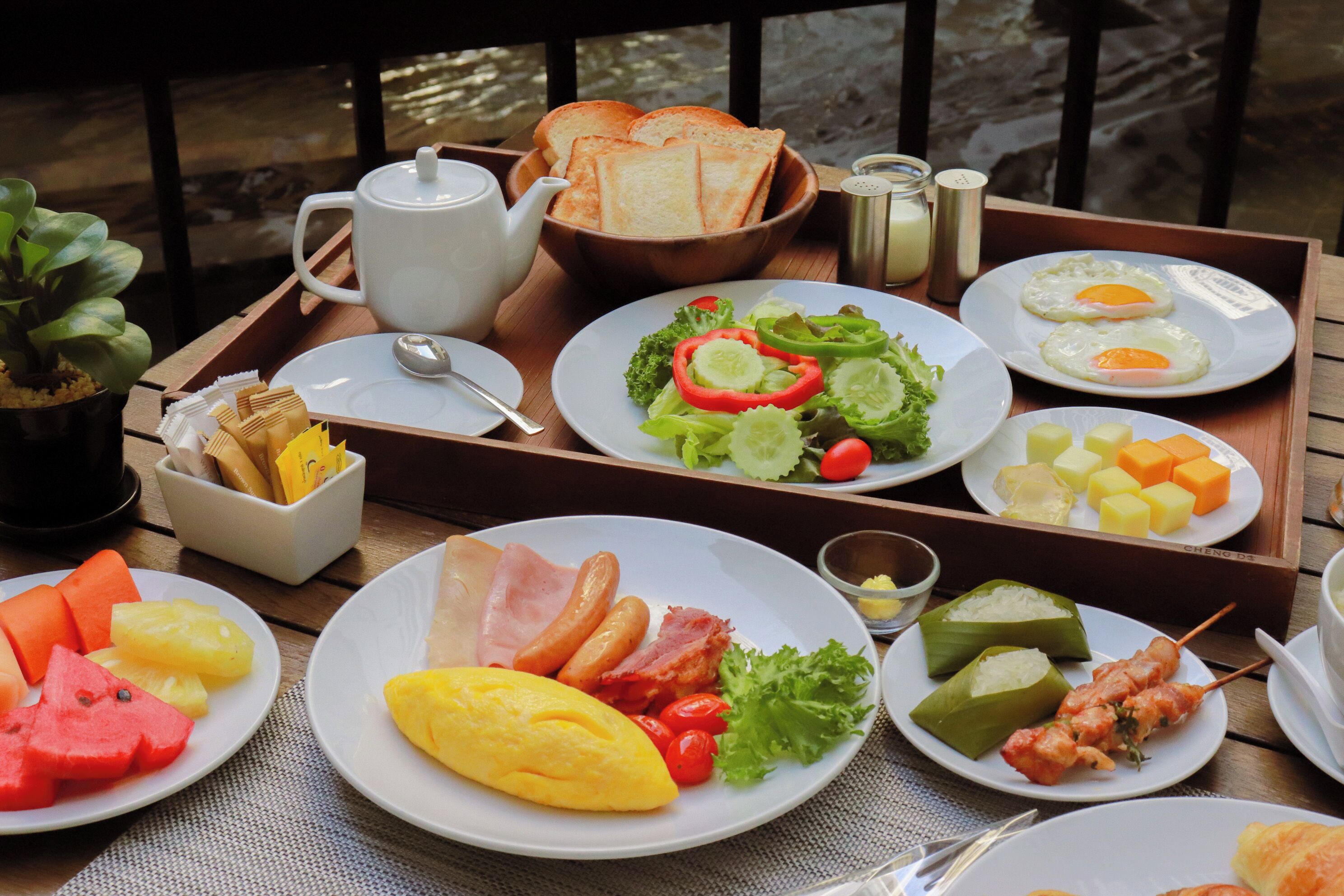 A tray with breakfast items including eggs, toast, and various fruits.