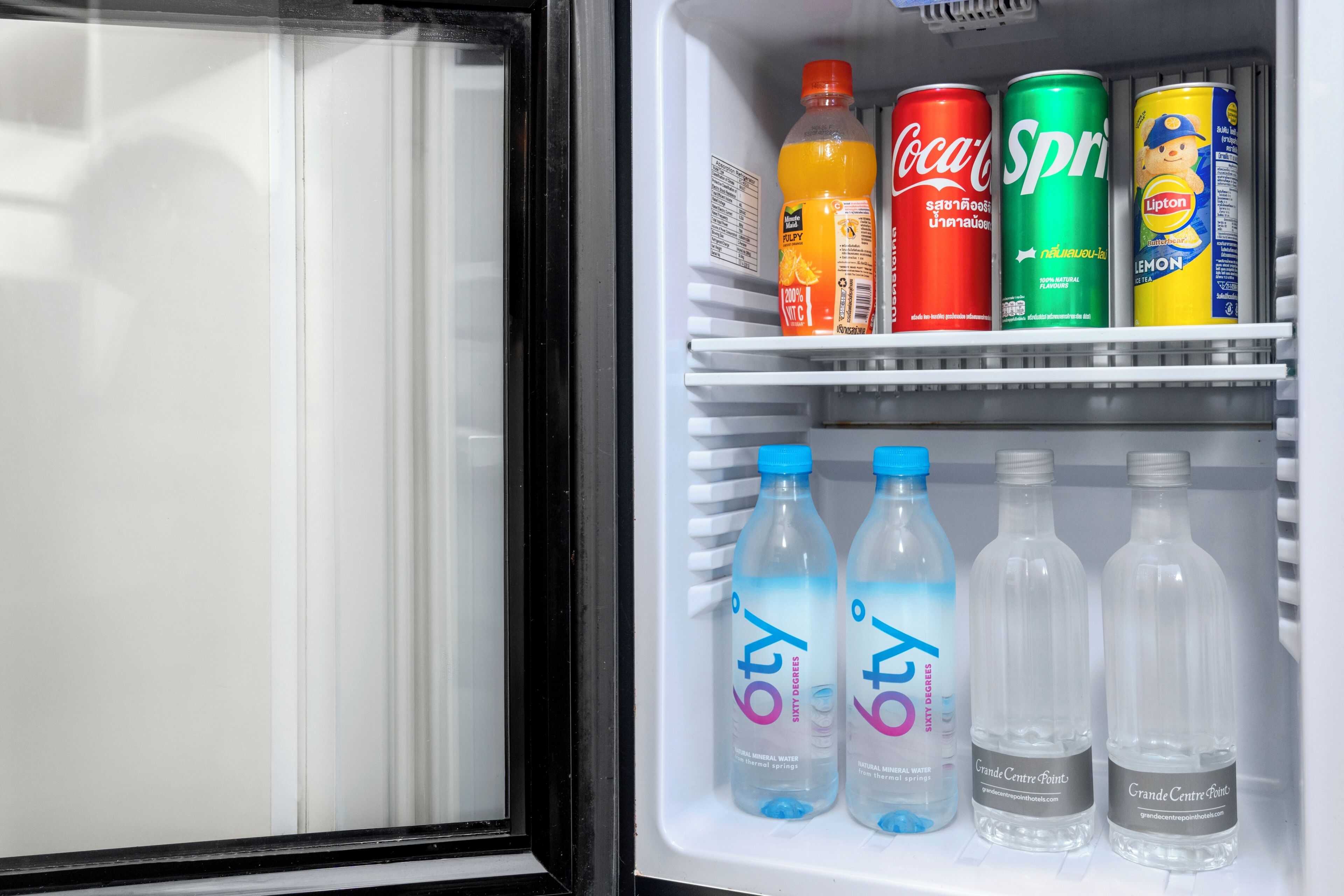 A refrigerator with various beverages including Coca-Cola, Sprite, and Lipton.