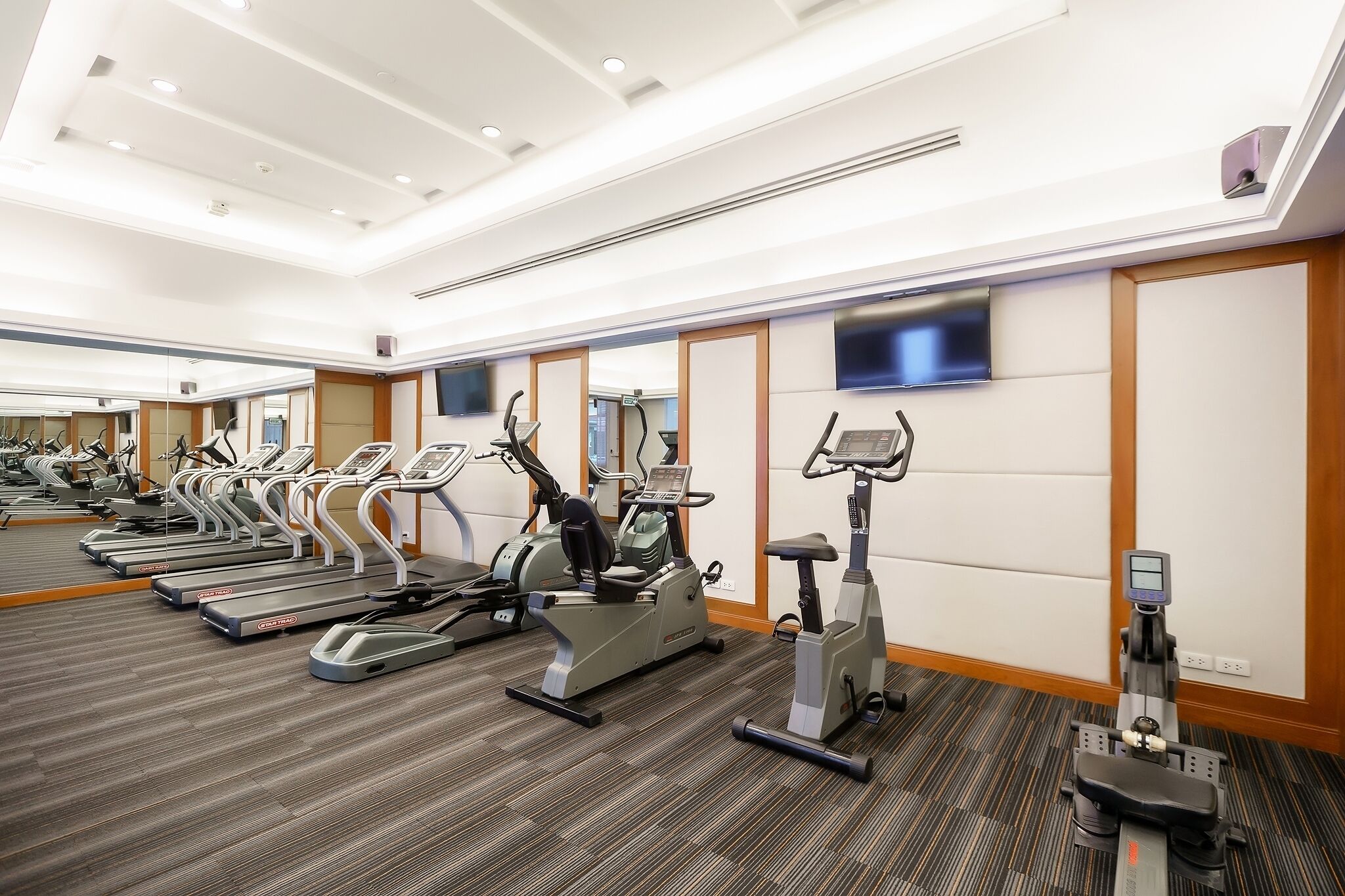 A gym with treadmills, elliptical machines, and stationary bikes.