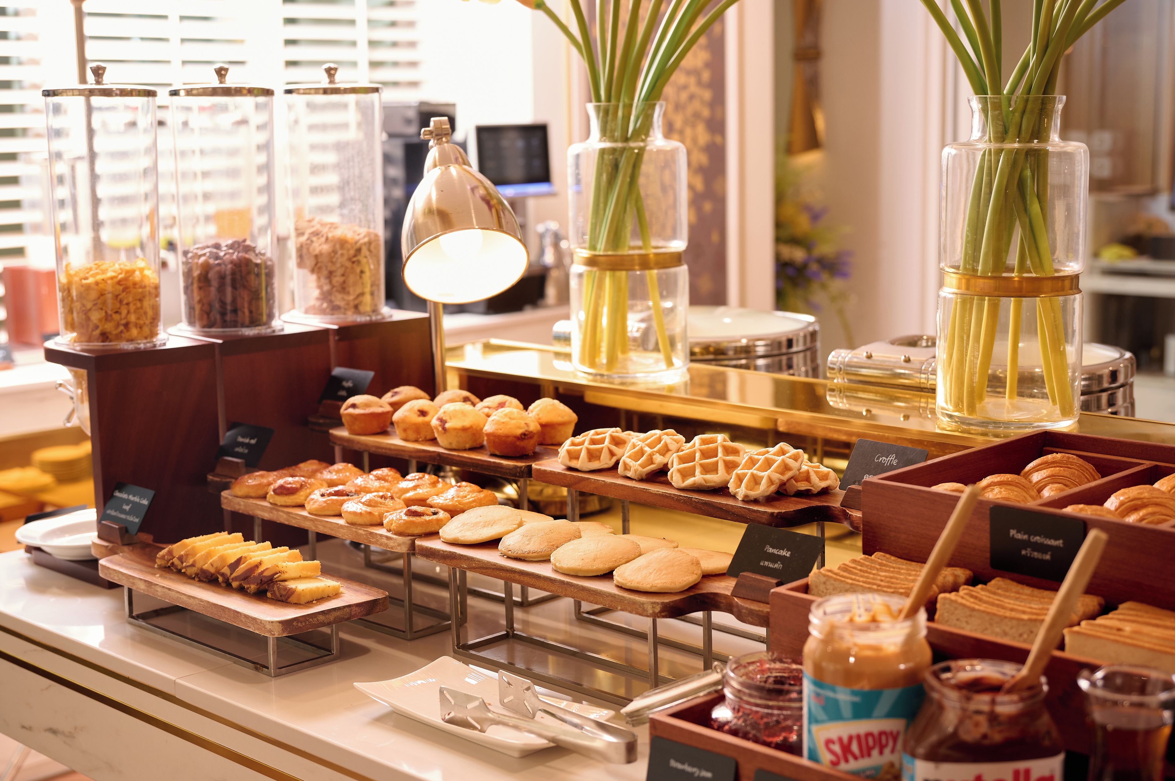A bakery display with various pastries and a jar of Skippy peanut butter.