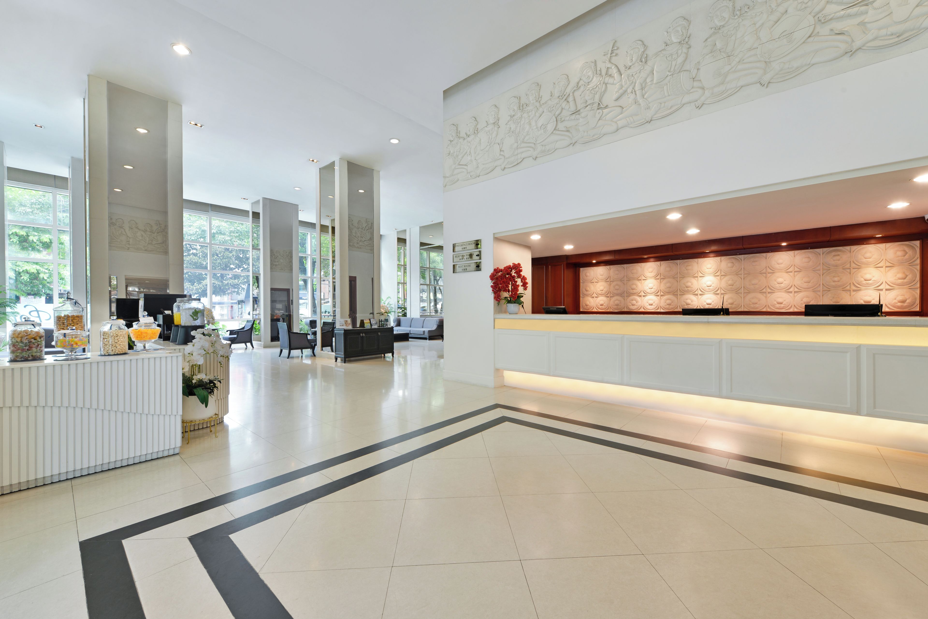 Eine geräumige Lobby mit Empfangstresen, einer Sitzecke und einem großen Fenster für viel Tageslicht.