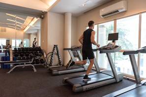 A gym with treadmills, dumbbells, and a mirror. - Centre Point Sukhumvit Thong Lo (Bangkok)