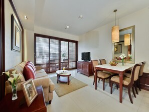 A spacious living room with a sofa, coffee table, and dining area with chairs and a table. - Centre Point Sukhumvit Thong Lo (Bangkok)