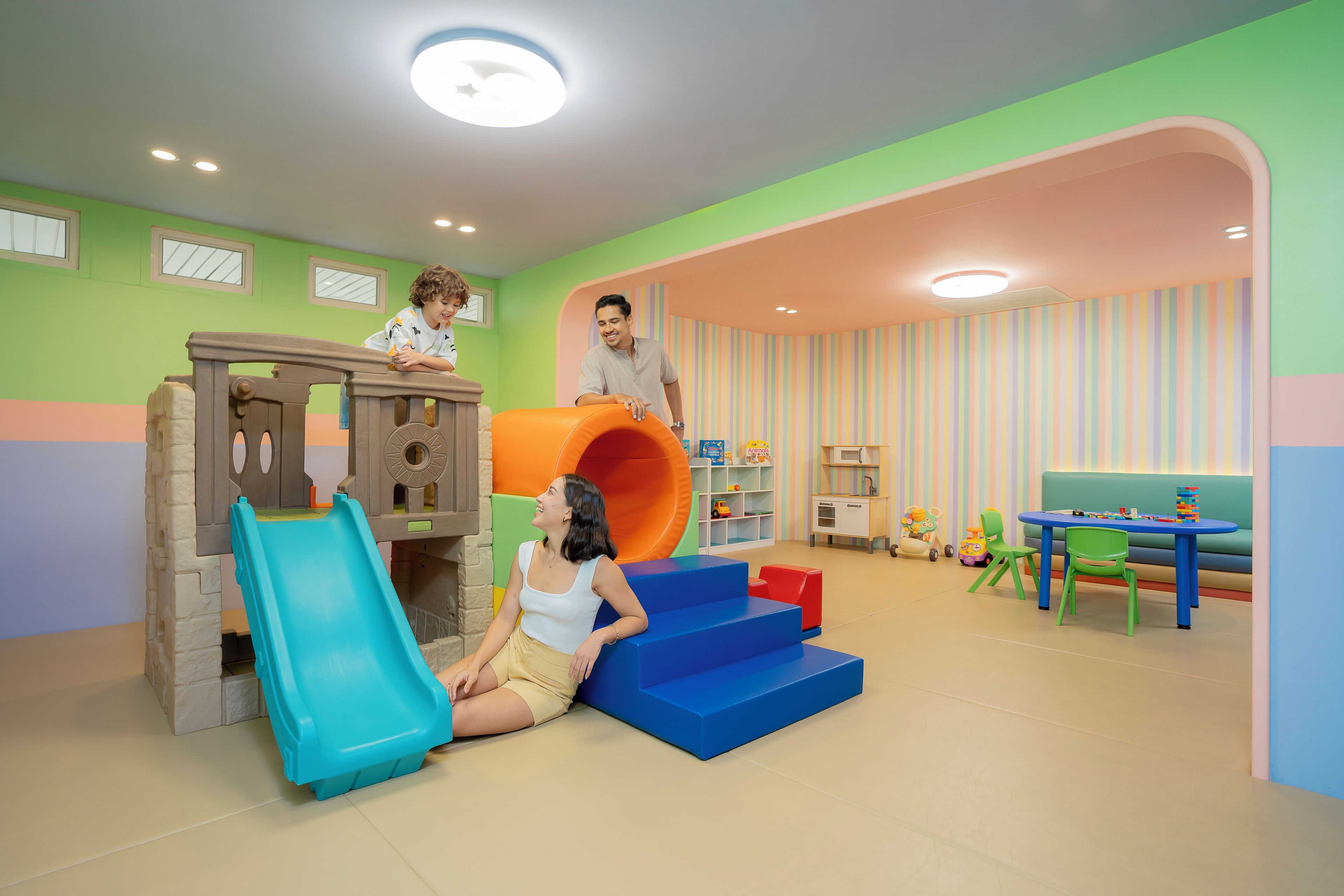 A play area with a slide, playhouse, and a table with toys.