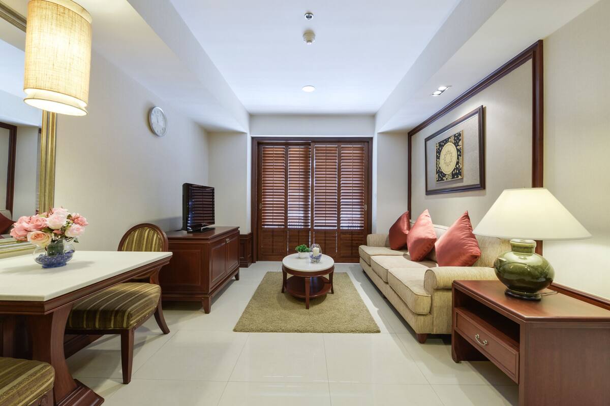 A living room with a dining table, sofa, and a TV.