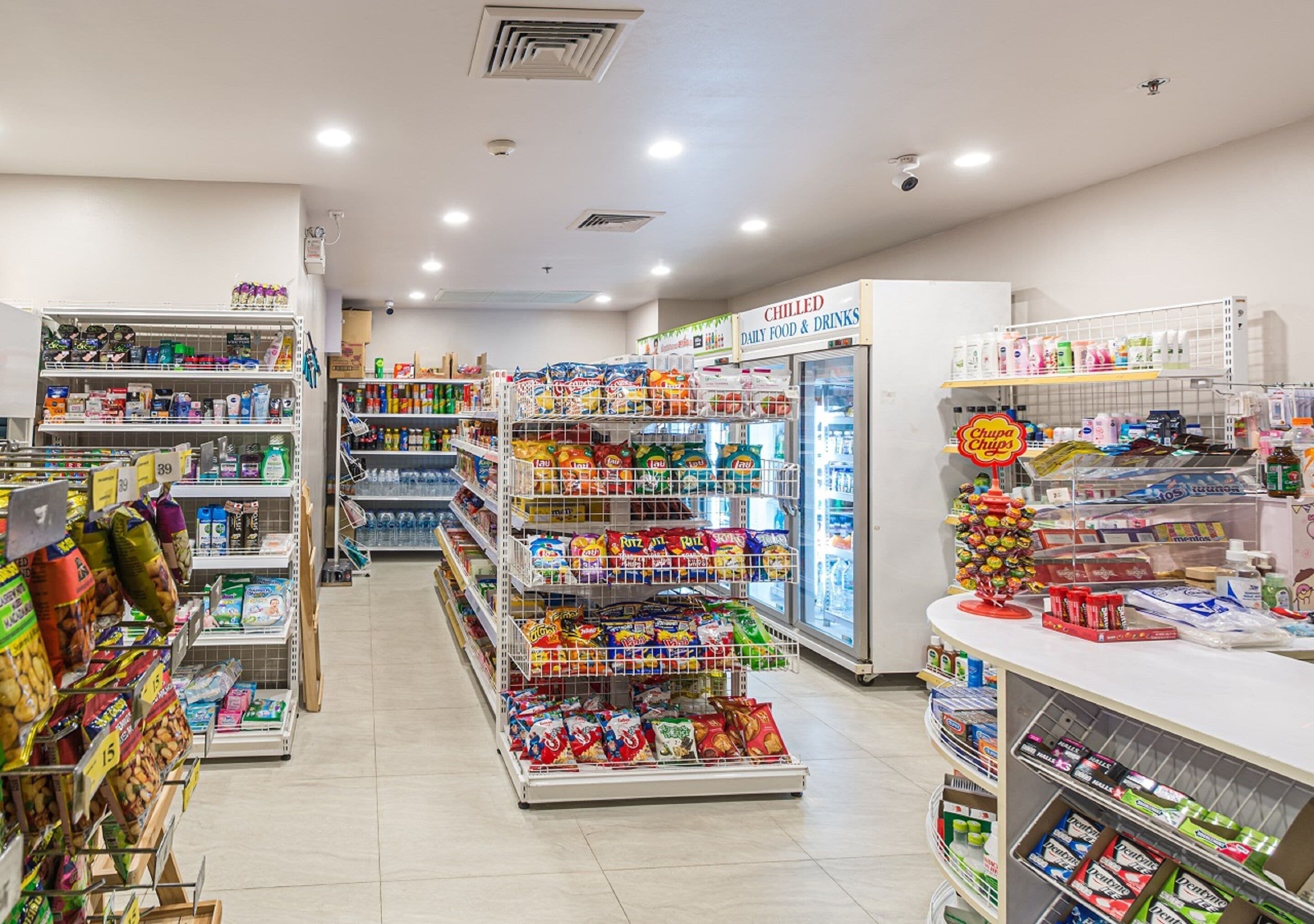 A grocery store with shelves stocked with snacks, beverages, and packaged goods.